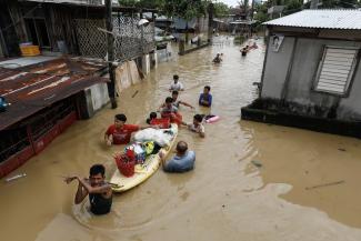 Residents wade through flood water caused by typhoon Noru in Bulacan province, Philippines, 2022.