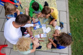 Children and a caregiver play in a German daycare center.