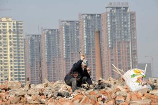 Schrottverwehrter sammelt Altmetall aus abgerissenen Häusern im chinesischen Shenyang