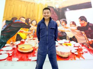Wang Cheng Yun vor einer Arbeit aus seiner Serie „Der große Verbrauch“.