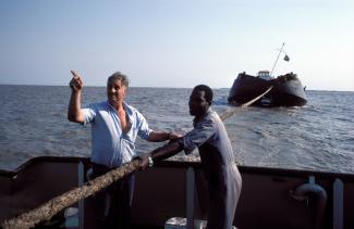 Ein ausländischer Mitarbeiter unterstützt einheimische Arbeiter im Hafen von Beira in Mosambik.