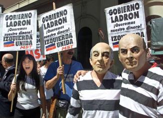 Im Dezember 2001 bezeichneten Demonstranten in Buenos Aires die Regierung als Dieb und forderten ihr Geld zurück – einige trugen Masken des damaligen Präsidenten Fernando de la Rúa.