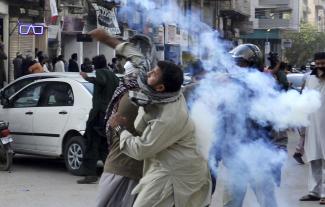 A fanatic tossing a tear-gas canister towards police during anti-Asia-Bibi protests in Karachi in February 2019.