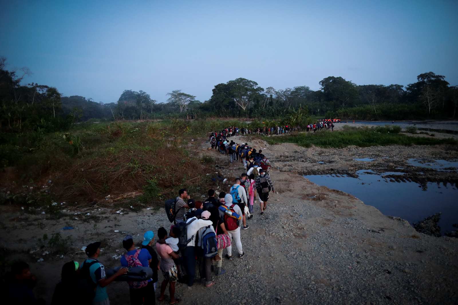 Migrants queue in Bajo Chiquito, a Panamanian community in the Darién region, after crossing the jungle.