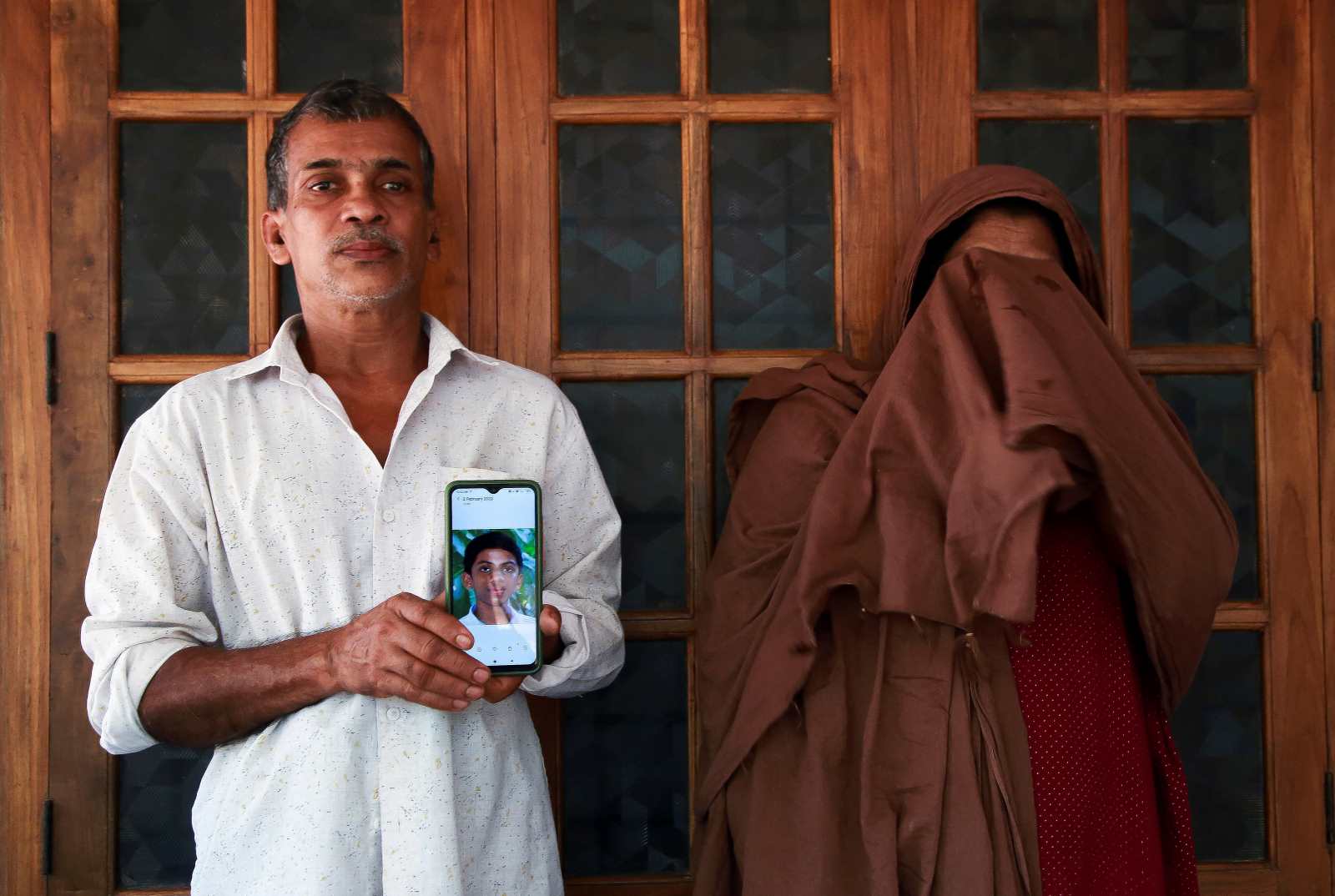 The parents of a boy who died from Nipah in Kerala in 2021 with a photo of theiris son.