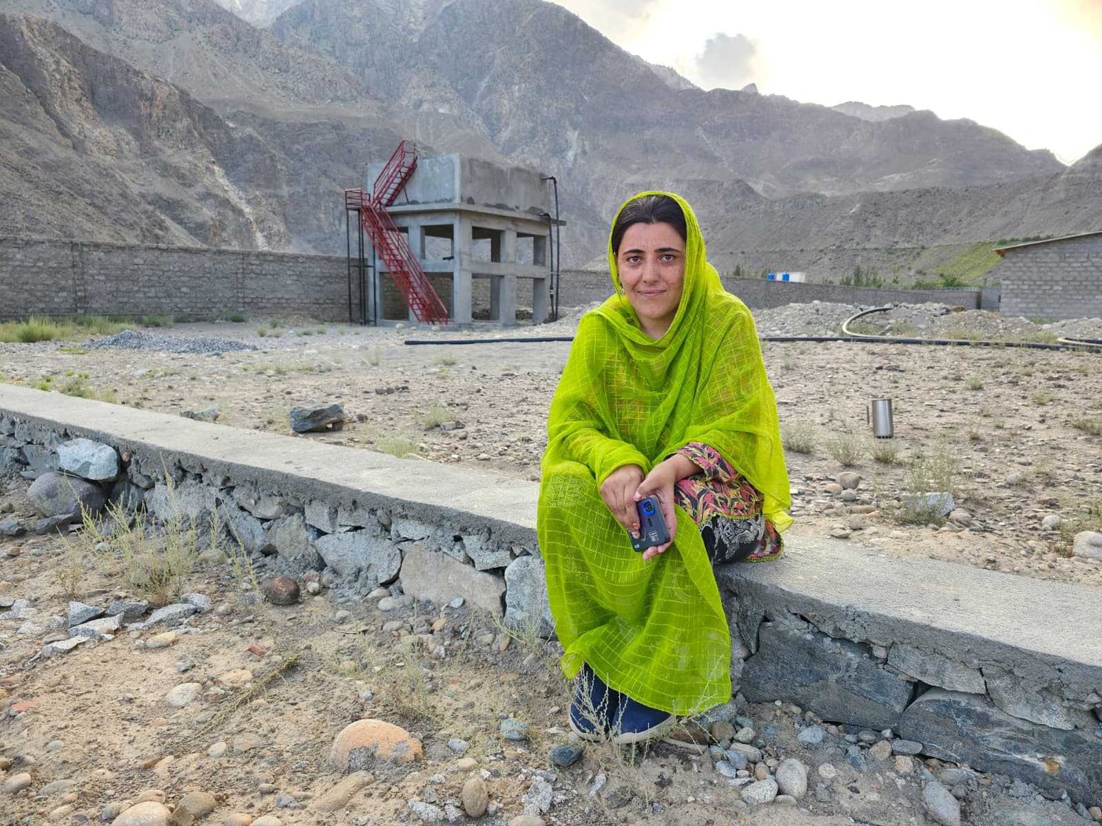 Parveen Bibi in Darkut Colony vor einem Wassertank, der mittels einer solarbetriebenen Pumpe befüllt wird.