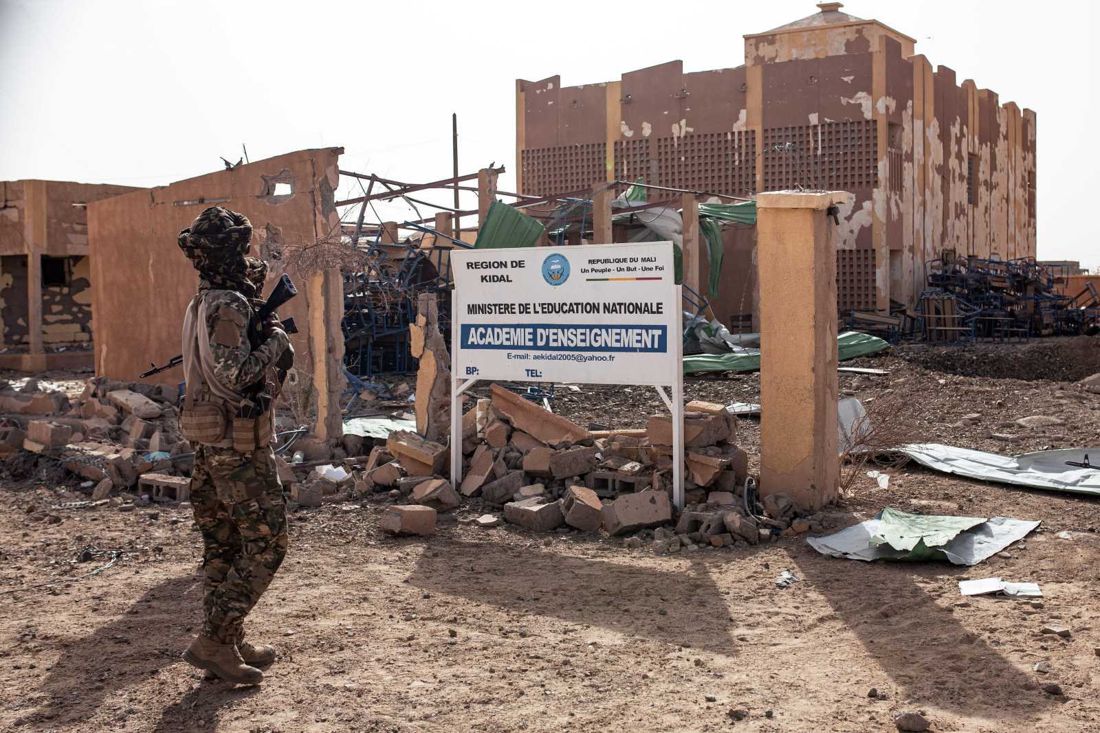 A fighter of the Azawad Liberation Front (FLA) stands in front of the Regional Academy of Education building in Kidal, northern Mali, in May. The building was severely damaged during fighting prior to the FLA’s capture of the city.