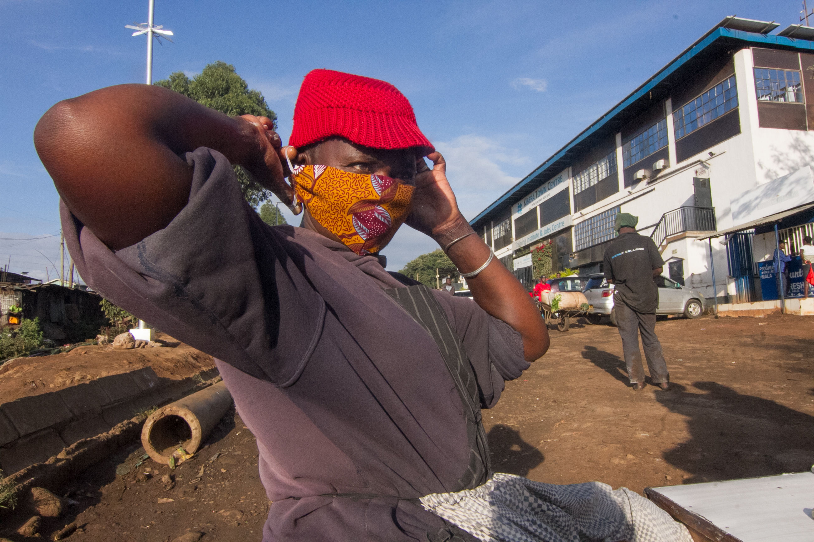 A Kenyan market woman using an improvised face mask.