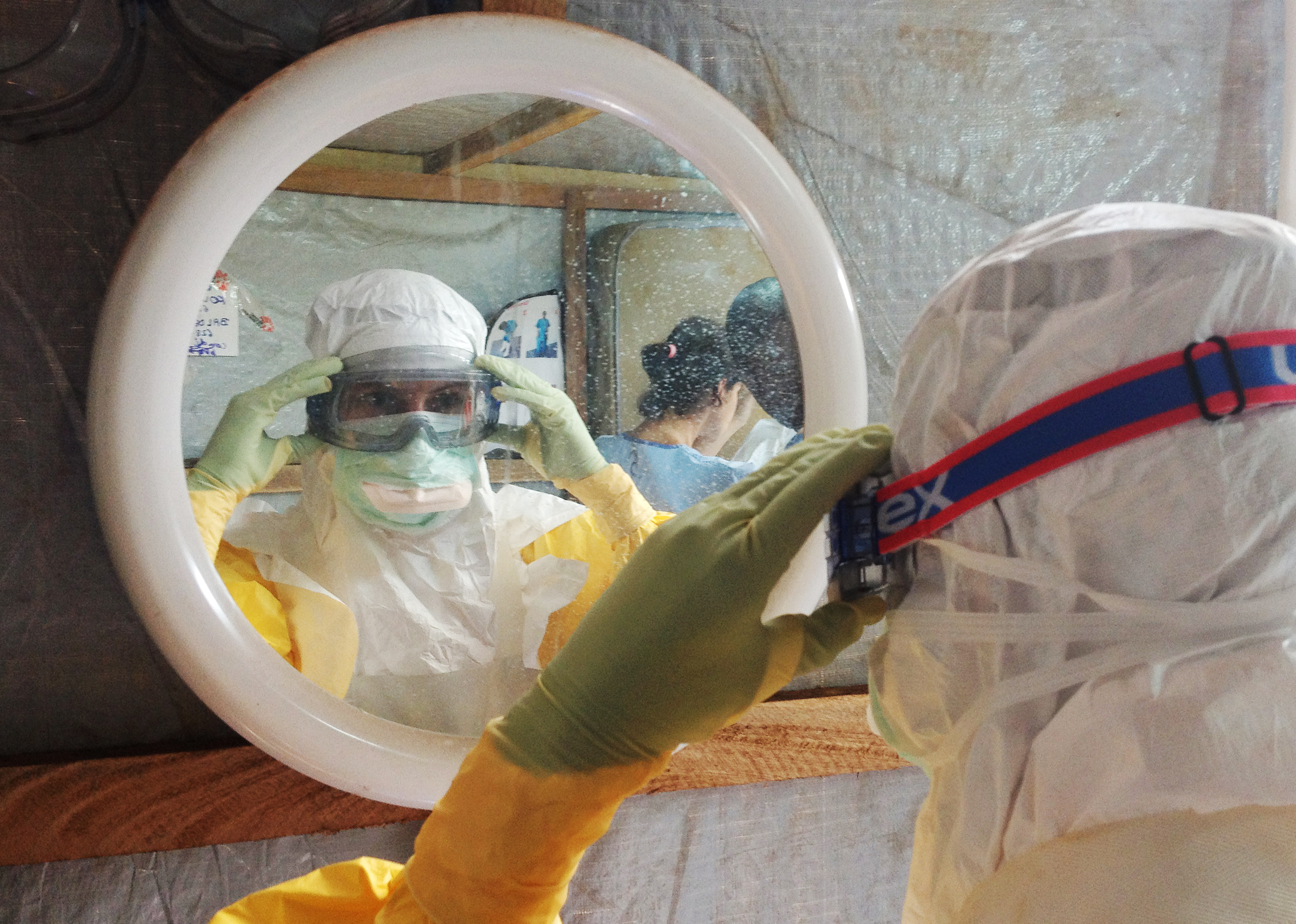 MSF nurse putting on protective gear in Guiniea.