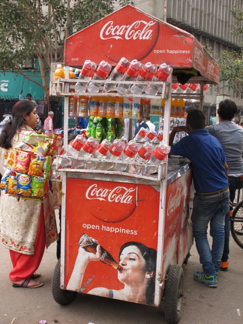 Big multinational corporations promote unhealthy eating and drinking habits in developing countries: sales stall in New Delhi.