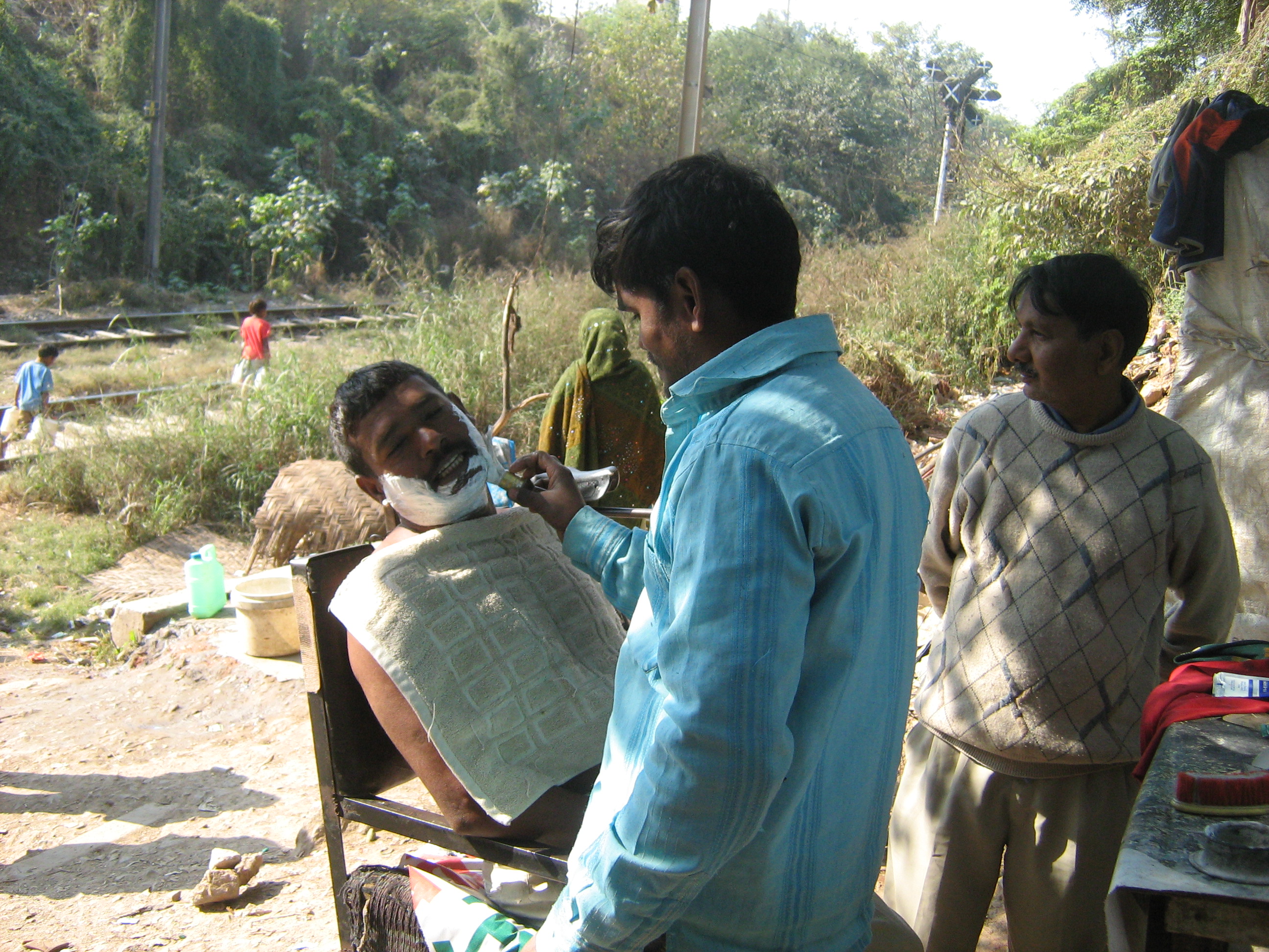 dem Informal settlements matter too: slum barber in Delhi.
