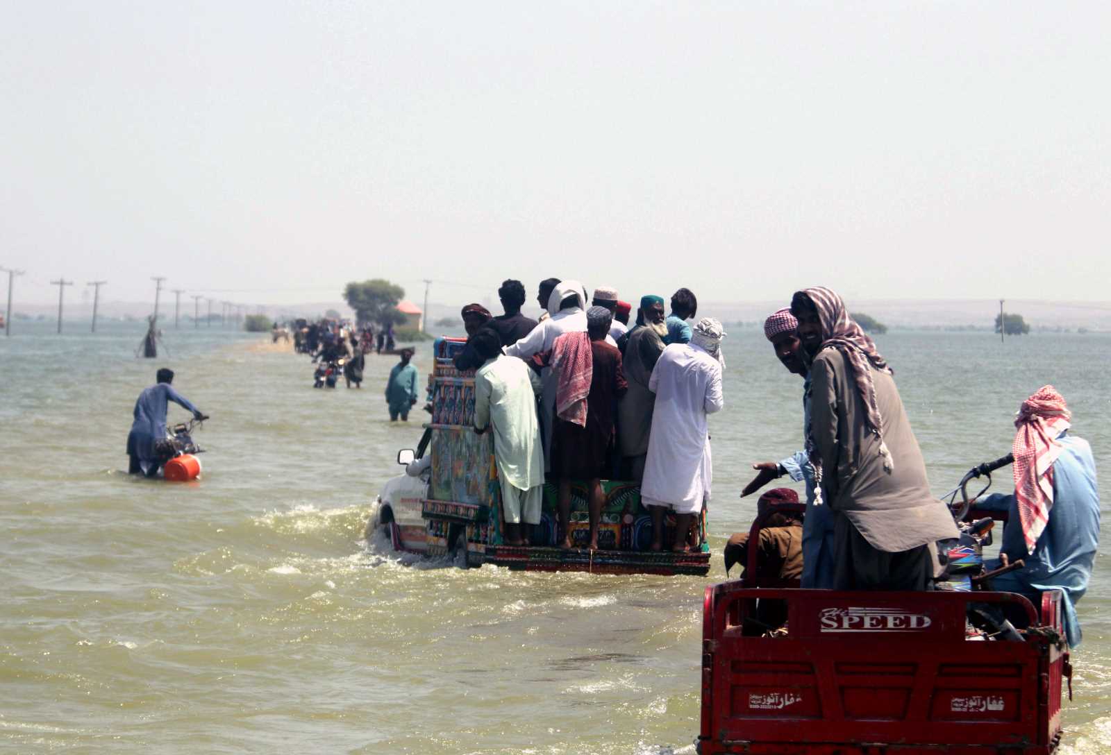 People fleeing on submerged highway in Sindh Province.