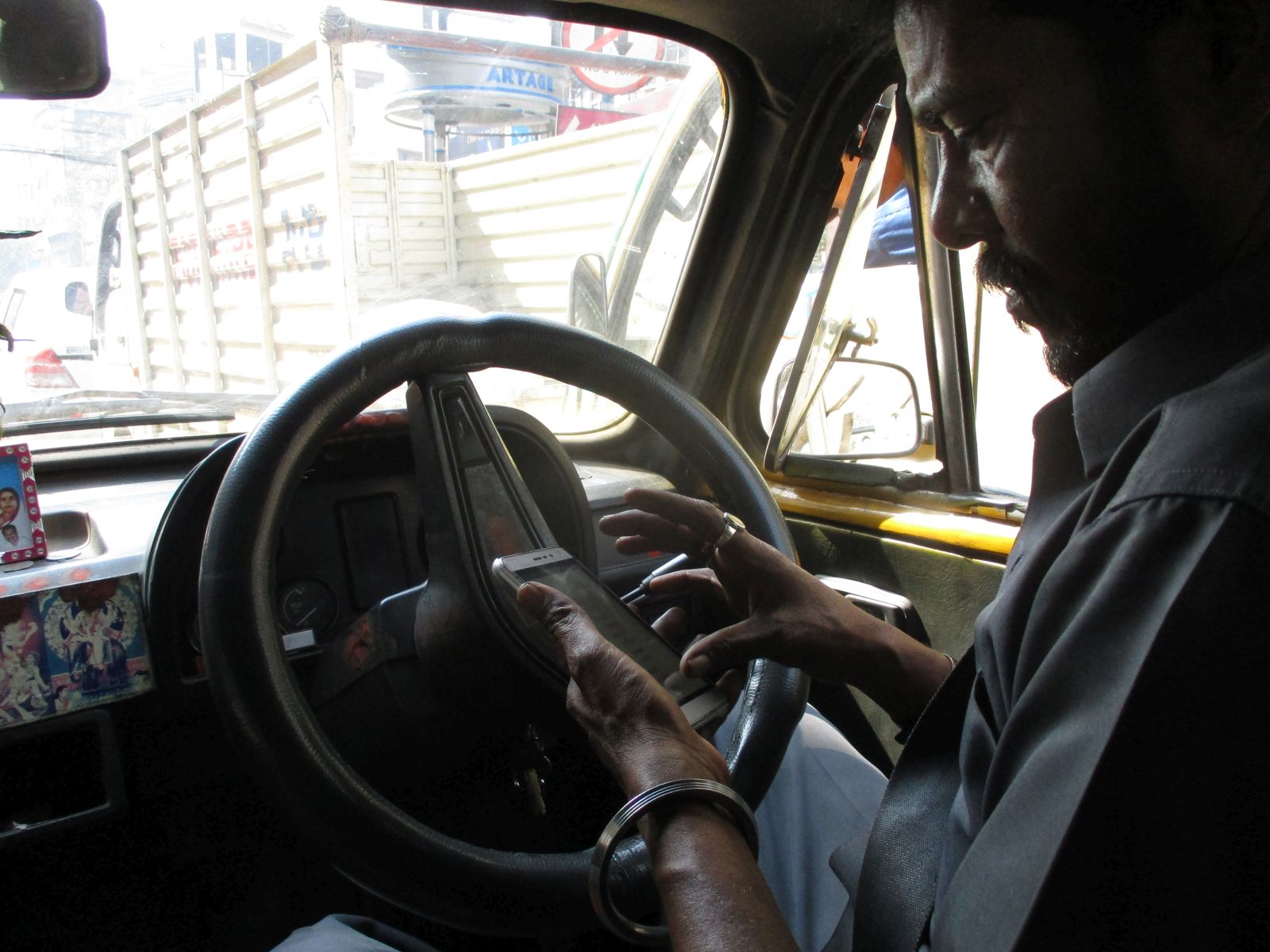 dem Taxi driver checks address on smartphone in Kolkata.