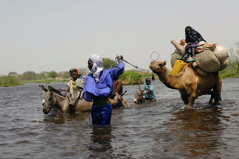 People crossing a tributary to Lake Chad.