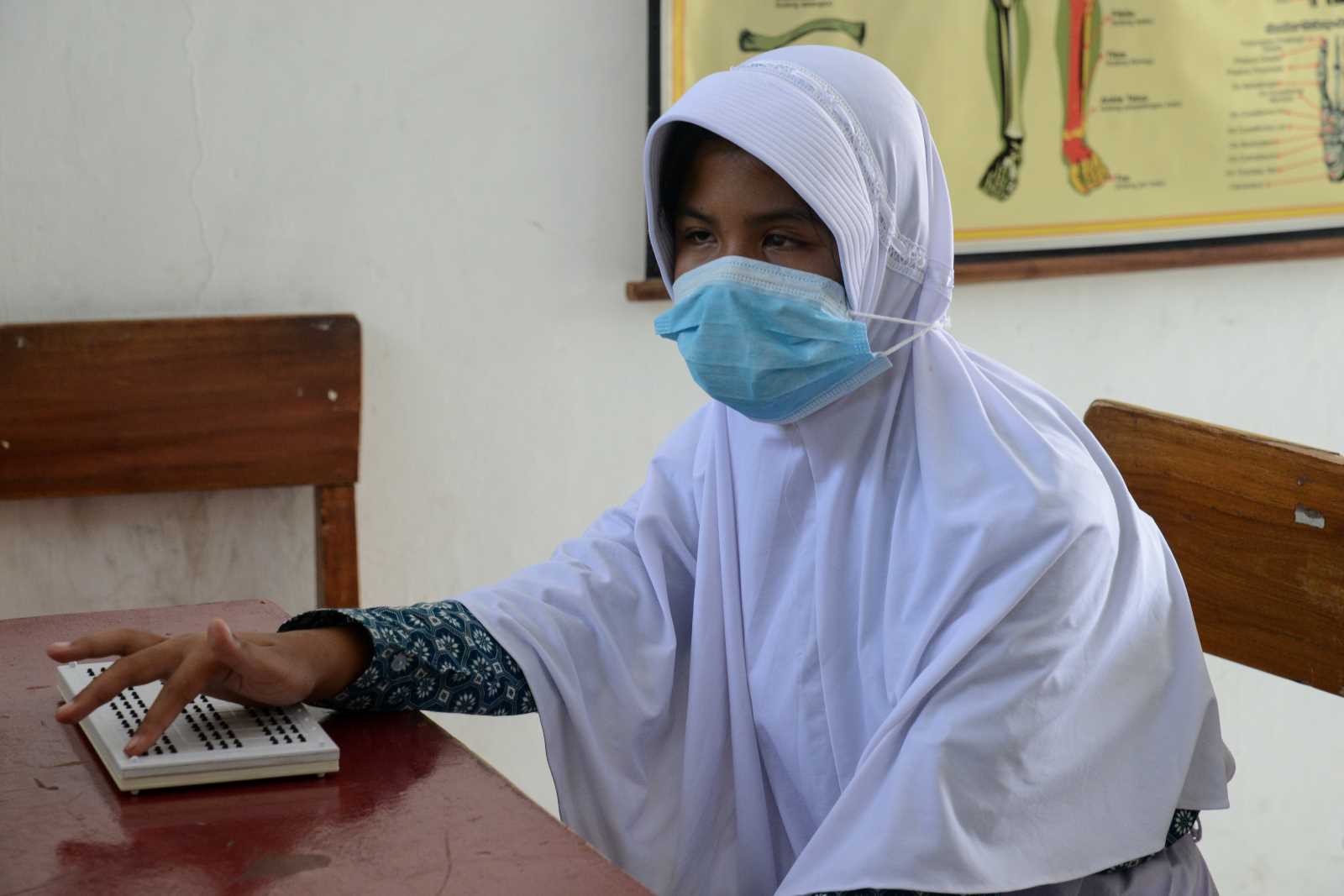 picture alliance / NurPhoto / Adriana Adie Student participating in Braille lesson during pandemic.