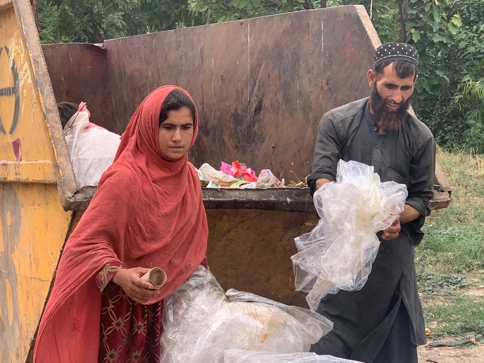 Father and daughter picking waste in Islamabad.