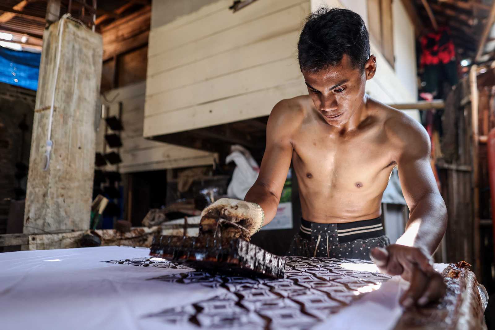 picture alliance / NurPhoto / Garry Lotulung Printing traditional Javanese textile patterns in a small-scale workshop.