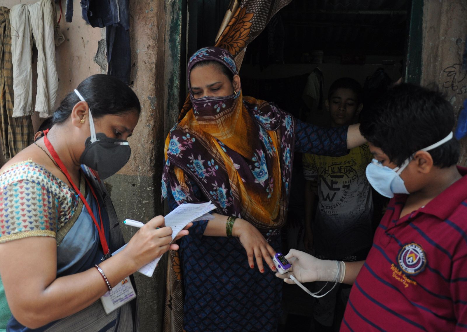 Community health workers checking people’s temperature in view of Covid-19 threat in a Mumbai slum in October 2020.
