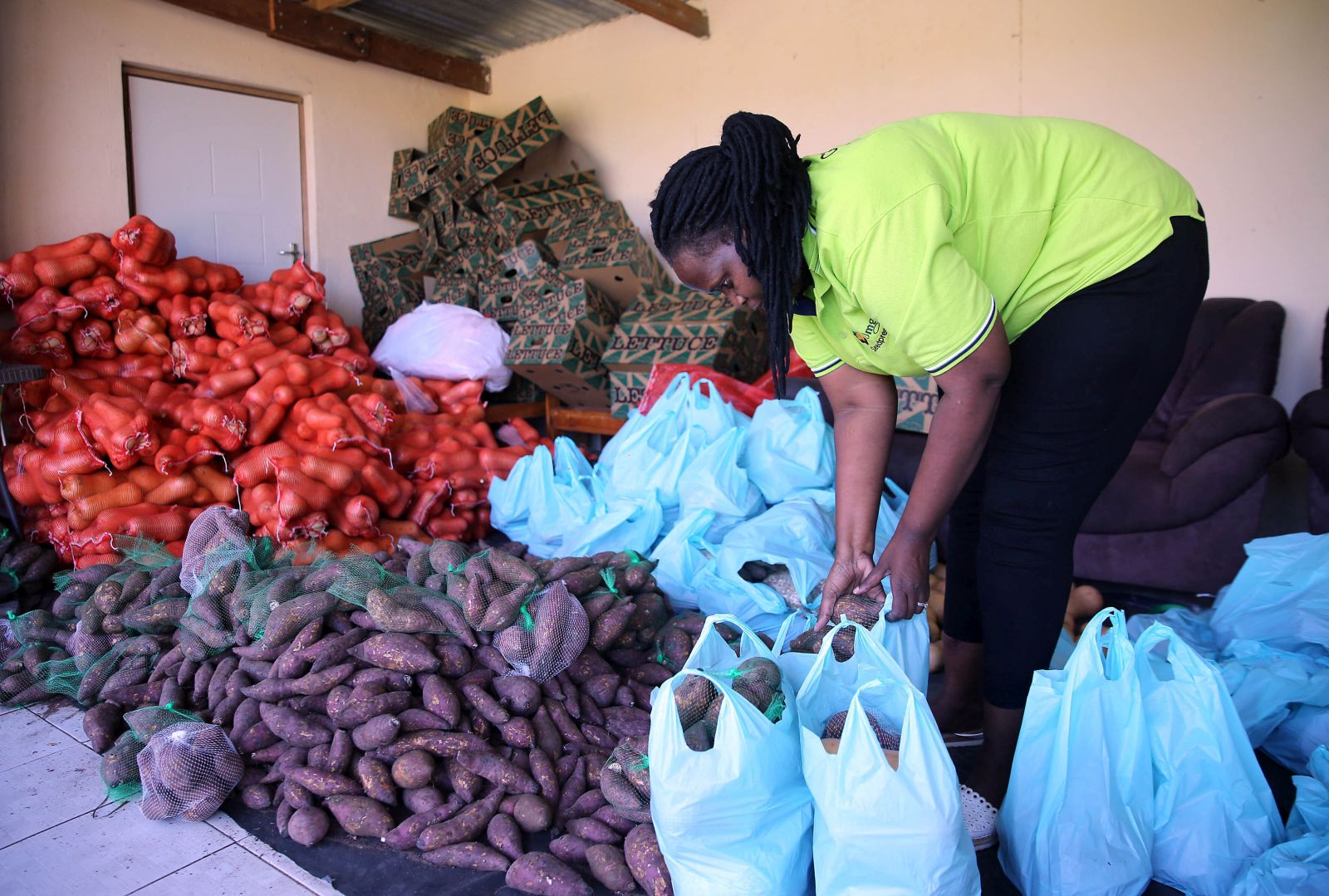 picture-alliance/abaca/RealTime Images/ABACA Eine Frau holt sich ein Lebensmittelpaket im Township KwaZulu Natal in Durban, Südafrika, ab, das eine Vereinigung gegen verborgenen Hunger bereitstellt.
