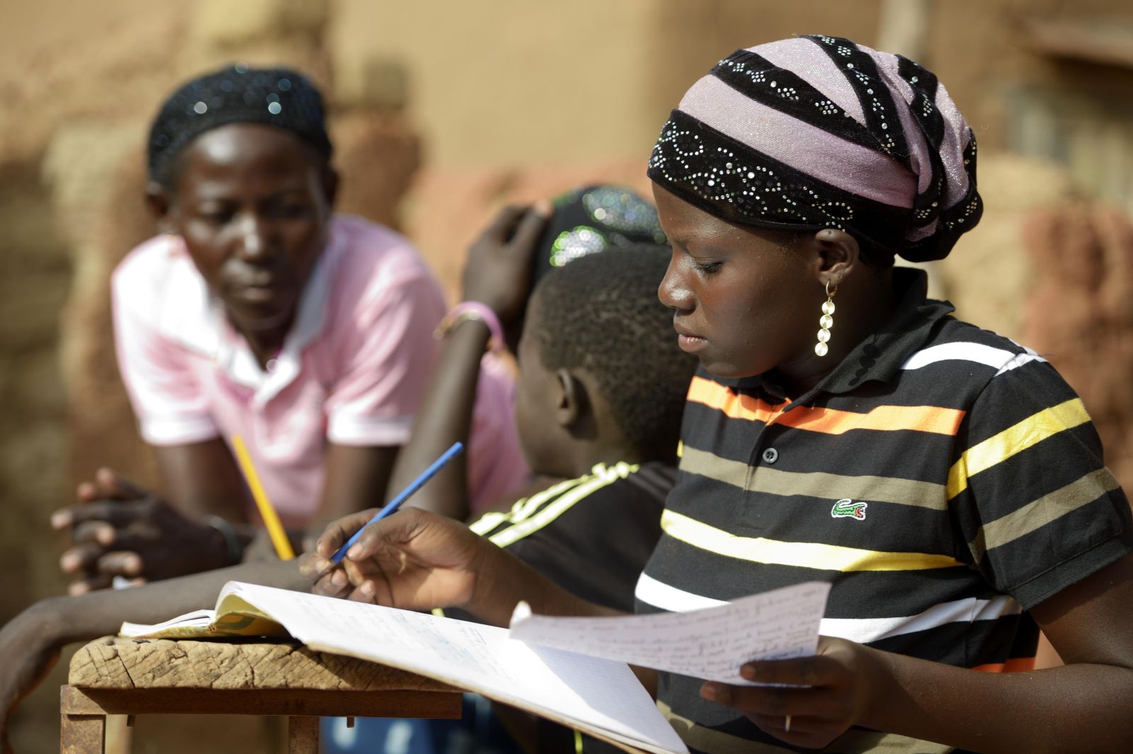 Eine Schülerin im ländlichen Burkina Faso bei den Hausaufgaben.