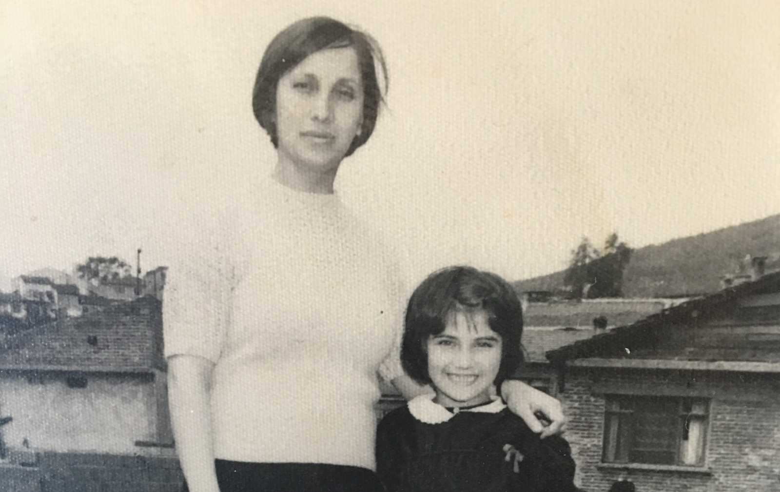 Canan Topçu 1972 in der Türkei, kurz vor ihrer Migration nach Deutschland. Sie ist mit ihrer Klassenlehrerin in Gemlik, südlich von Istanbul, auf dem Schulgelände zu sehen.