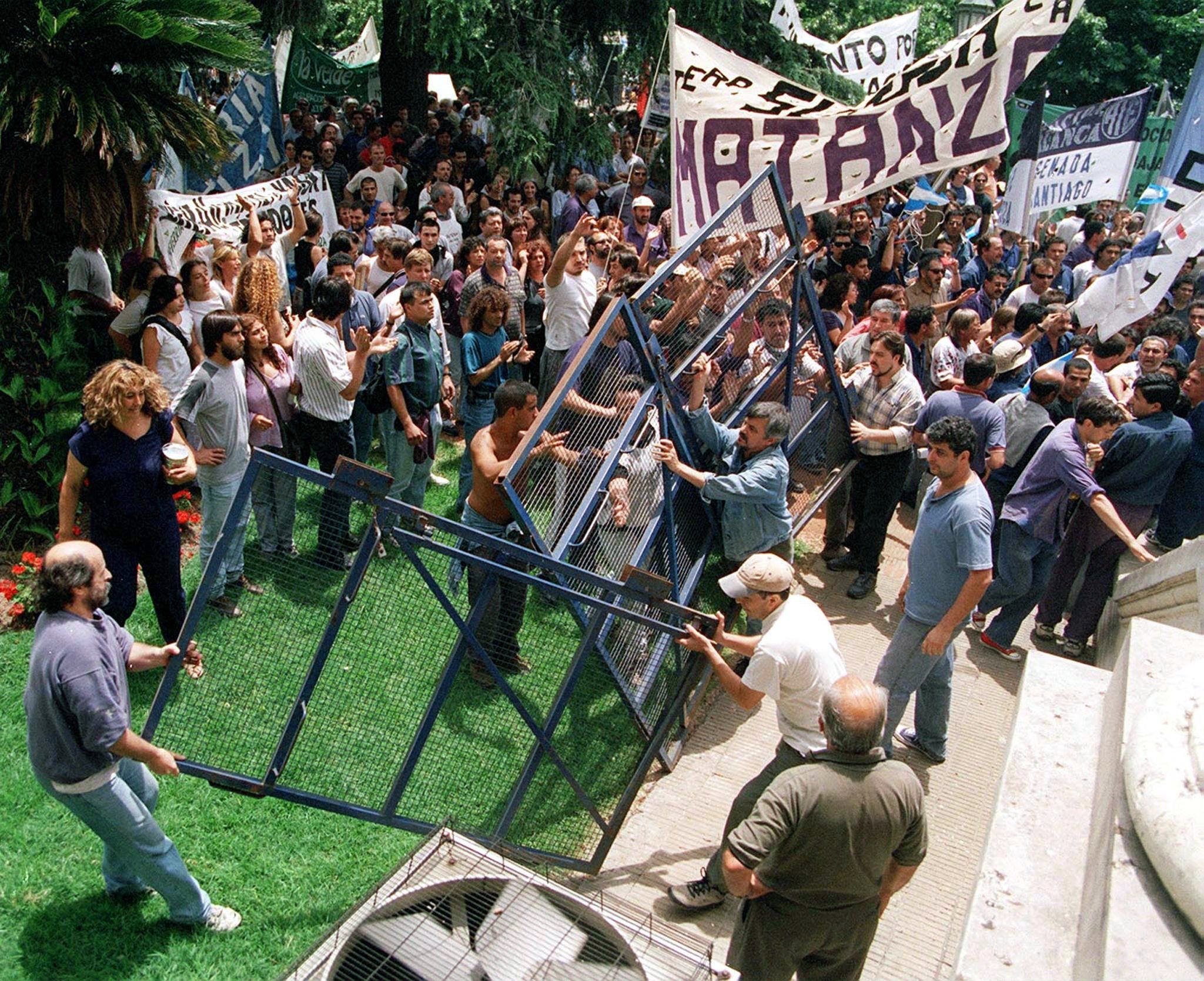 Argentinians storm the barricades in front of the Ministry of Justice in Buenos Aires, December 2001.