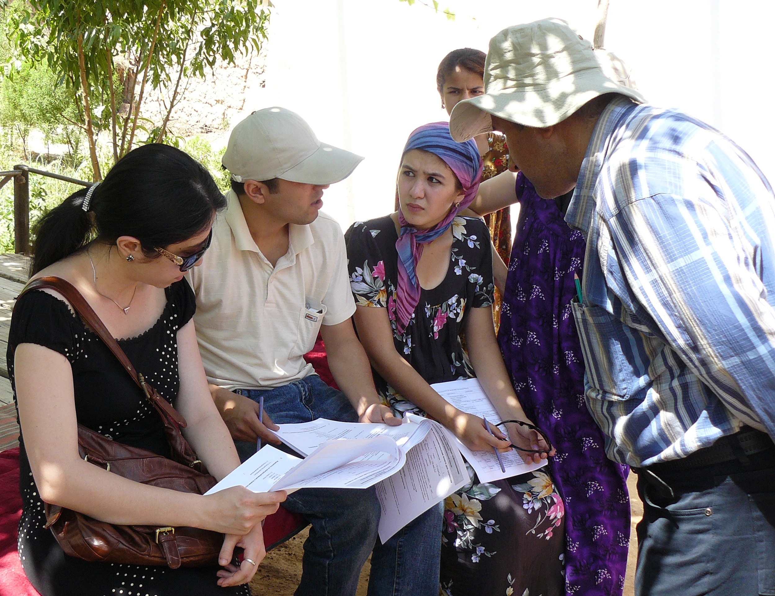 Bliss Interviewees discussing on questionnaires in Tajikistan.