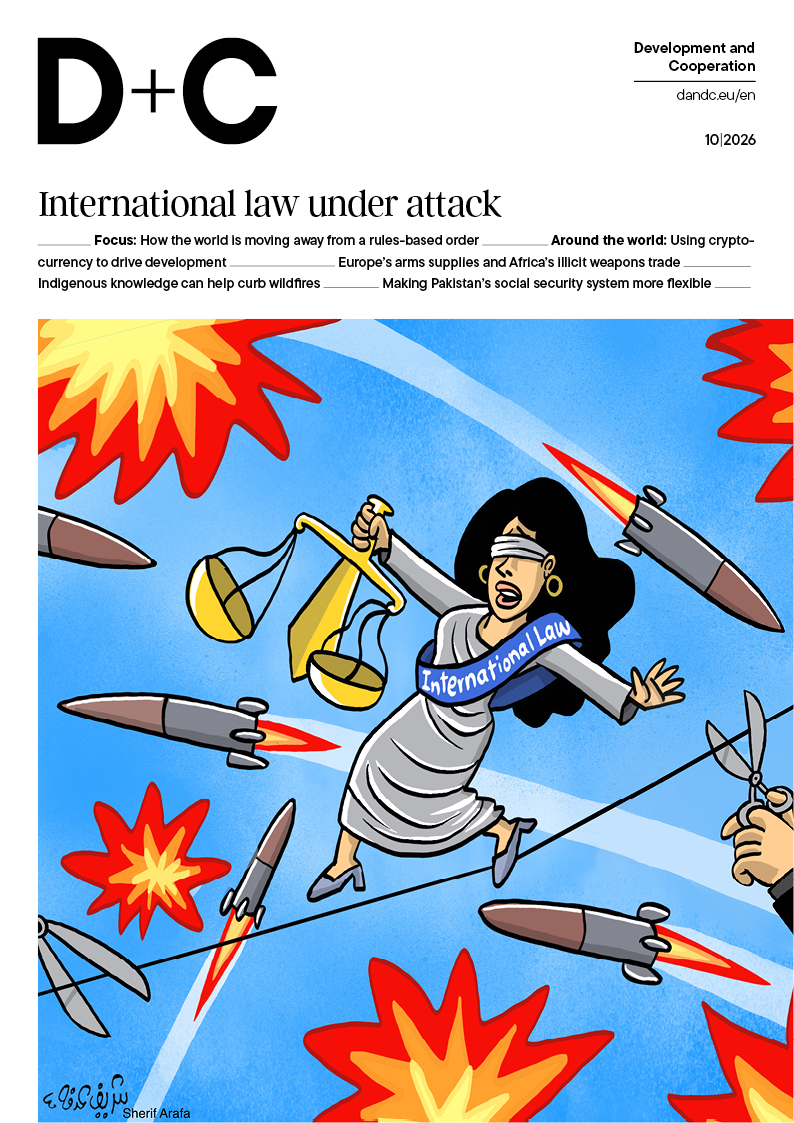 Magazine cover: cartoon blindfolded Lady Justice with scales and an “International Law” sash, surrounded by missiles and explosions.