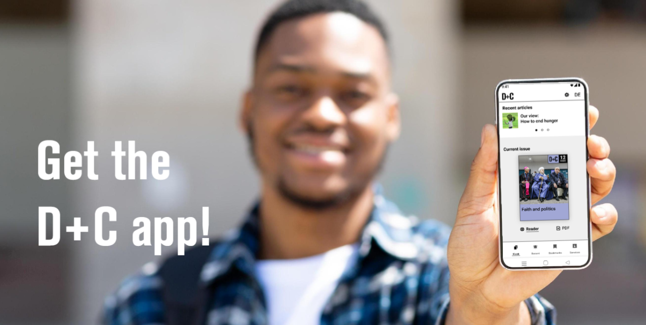 A man holds a smartphone with the D+C App on it in his hand.