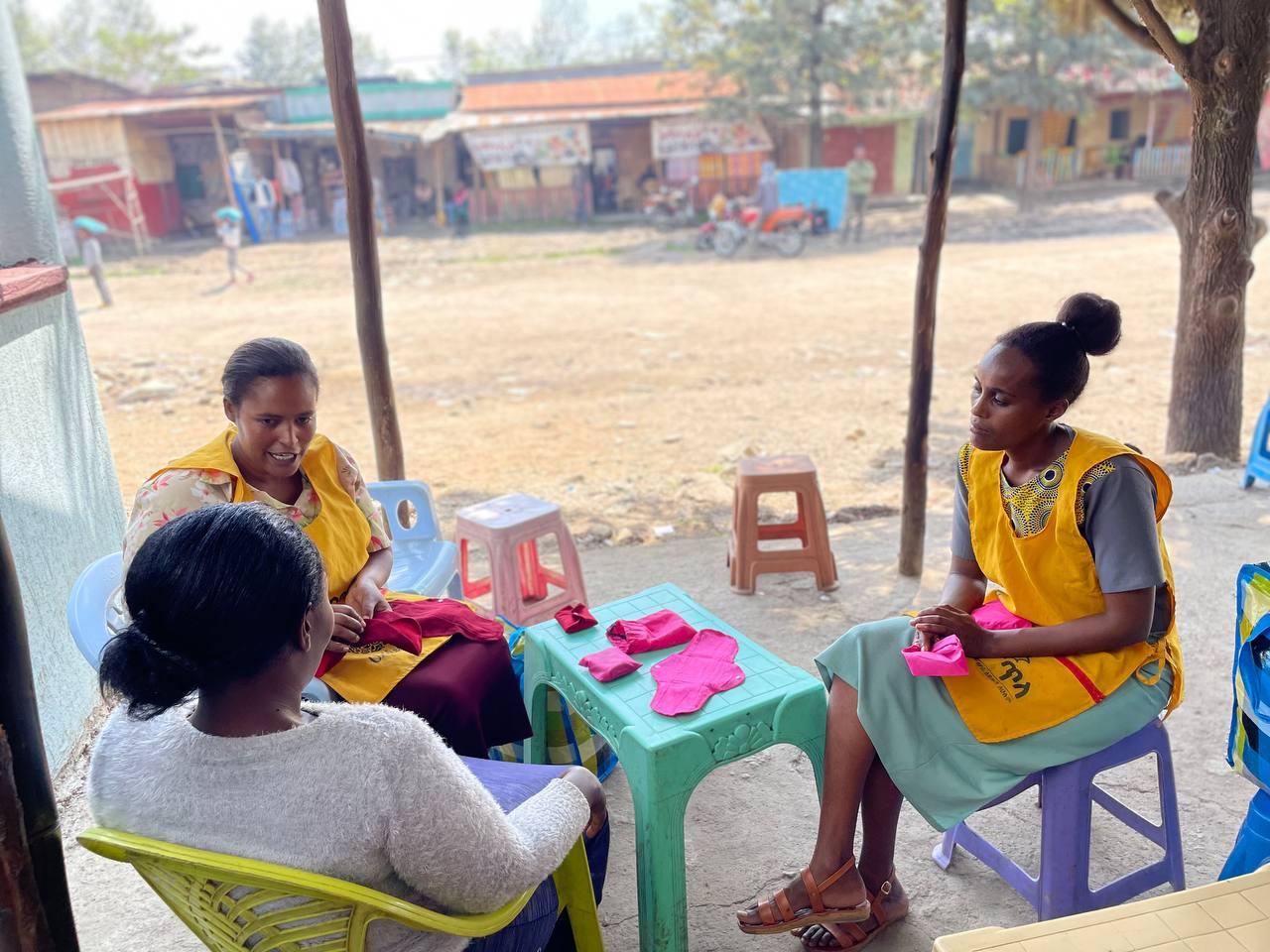 Saleswomen from Mela for Her show potential customers their reusable menstrual health products. 