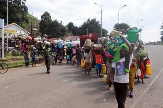 Geflüchtete aus der Demokratischen Republik Kongo passieren im Oktober 2022 das Grenzgebiet von Bunagana in Uganda. 