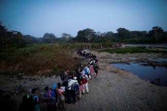 Migrants queue in Bajo Chiquito, a Panamanian community in the Darién region, after crossing the jungle.
