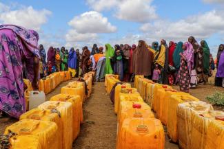 Von der anhaltenden Dürre vertriebene Frauen stehen im Lager Kaam Jiroon in Somalia für Wasser an.