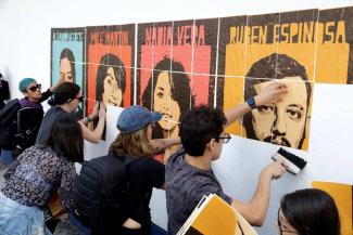Angehörige von Mordopfern befestigen Plakate mit Porträts der Getöteten an der Wand am Eingang des Büros der Generalstaatsanwaltschaft von Mexiko-Stadt und fordern Gerechtigkeit.