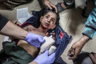 Injured Gazan boy receives medical treatment on a hospital floor in Gaza. 