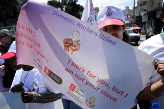 A migrant worker carries a banner at an annual Workers’ Day rally in Beirut, Lebanon.