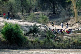 Simbabwische Migrant*innen warten am trockenen Flussbett des Limpopo, um nach Südafrika zu gelangen.
