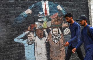 picture alliance/Middle East Images/Raja Imran Ein Mural an einer Wand der Punjab University in Lahore, Pakistan, versinnbildlicht die Bürde der Armen, die den Lebensstil der Elite schultern.