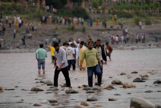 People cross the Chenab River after the flow of water was halted from a dam, at Akhnoor, on the outskirts of Jammu, India in May. 