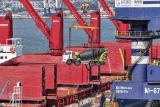 Verladen eines in China gefertigten Lkw zum Export nach Afrika am Yantai Port in der Provinz Shandong. 