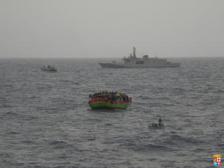 Die italienische Küstenwacht kommt Flüchtlingsboot vor der Küste Siziliens zu Hilfe.