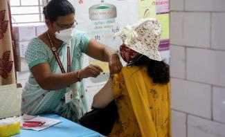 A health worker inoculates a woman against Covid-19 in Delhi in May.