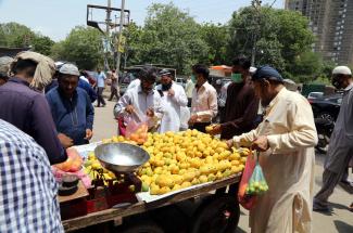Vendor sells mangoes on his pushcart at a roadside in Karachi.