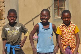 Kingsley Chiwandila, holding a homemade ball in his arms, with his peers.