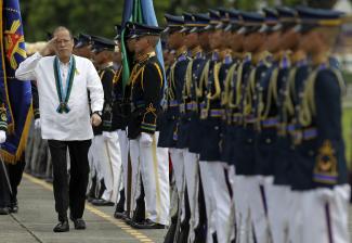 Richi B. Tongo/picture-alliance/dpa Präsident Benigno Aquino salutiert den Armed Forces of the Philippines in Manila.