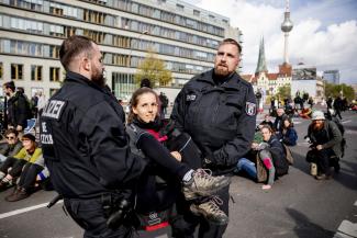 Soeder/picture-alliance/dpa Police officers carrying an XR protester away from a bridge in Berlin.
