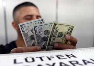 Checking dollar bills at an exchange bureau in Ankara.