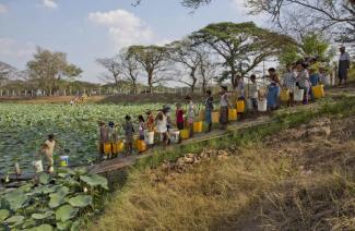 Myanmar’s dry season was unusually hot and long this year, leading to water shortages. People line up to fetch drinking water from a pond in Dala township south of Yangon in May.