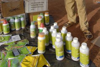 Burkina Faso dealer sells pesticides in village market. Farmers often use wrong quantities, damaging the soils.