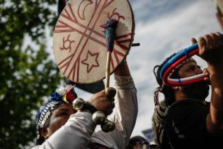 Angehörige indigener Völker machen Musik auf einer Demonstration für ihre Rechte in Santiago, Chile.